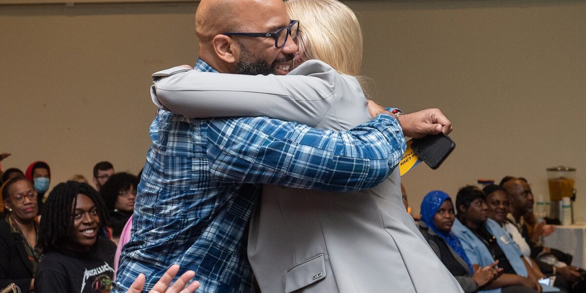 Two people hug during a ceremony